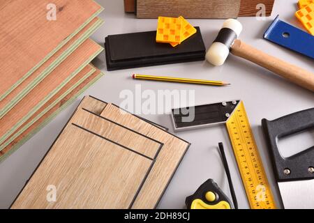 laminated flooring and assorted tools for placement on a gray table. Elevated view. Horizontal composition. Stock Photo