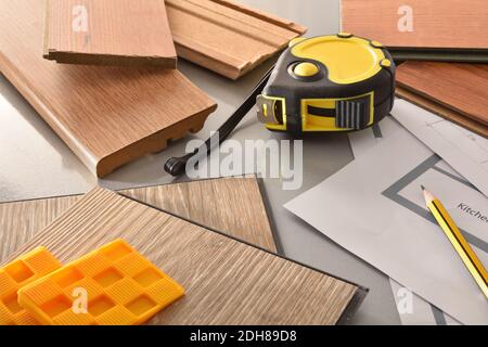 Detail of materials and tools on the work table of a parquet installer with plans. Top elevated view. Stock Photo