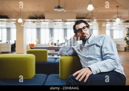 Portrait of mature man sitting on couch at corridor Stock Photo