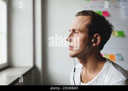 Close-up of engineer with headphones looking away in creative office Stock Photo