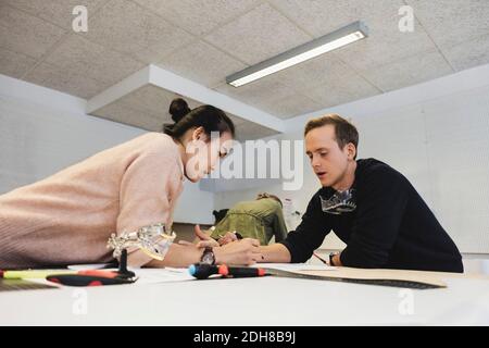 Engineers discussing about project on table in workshop Stock Photo