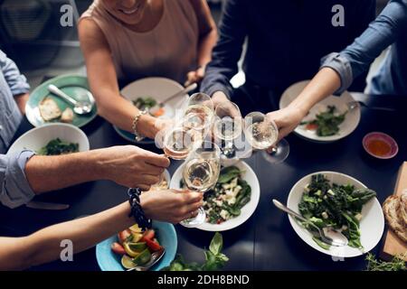High angle view of multi-ethnic friends toasting wineglasses Stock Photo
