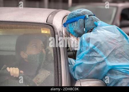 Thessaloniki, Greece - December 10, 2020. A medical worker wearing special suit to protect against coronavirus, conduct a 'drive through' rapid testin Stock Photo