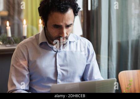 Concentrated blogger working on laptop in creative office Stock Photo
