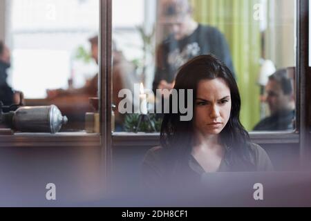 Serious female entrepreneur working on laptop in creative office Stock Photo