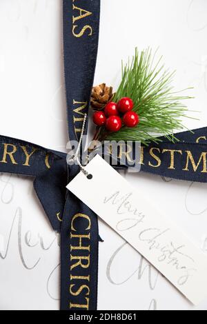 A close up of the ribbon, wrapping and label of a traditional Christmas gift with copy space Stock Photo