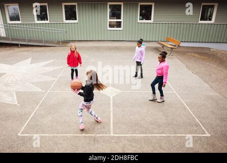 High angle view of children playing with ball in school playground Stock Photo