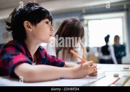 Serious students studying at desk in classroom Stock Photo