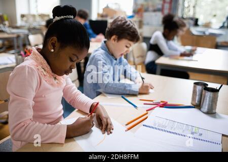 Serious students studying at desk in classroom Stock Photo