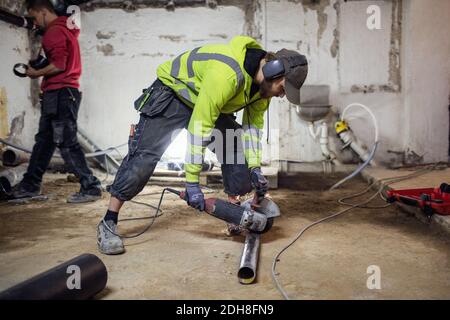 Plumbers working on pipes in abandoned basement Stock Photo