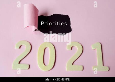 Priorities text on torn paper with Year 2021 background. Happy New Year Concept Stock Photo