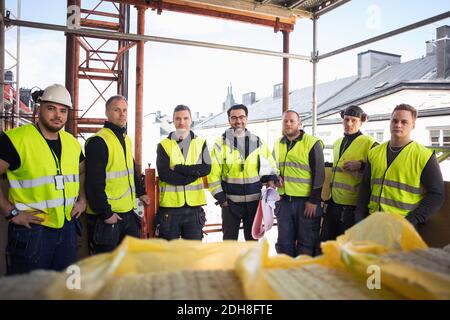 Portrait of confident manual workers standing at construction site Stock Photo