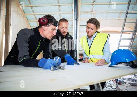 Low angle view of coworkers listening to manual worker at construction site Stock Photo