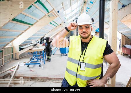 Portrait of confident manual worker wearing hardhat standing at construction site Stock Photo