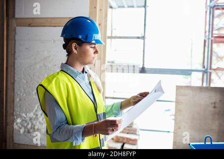 Confident female manual worker at construction site Stock Photo