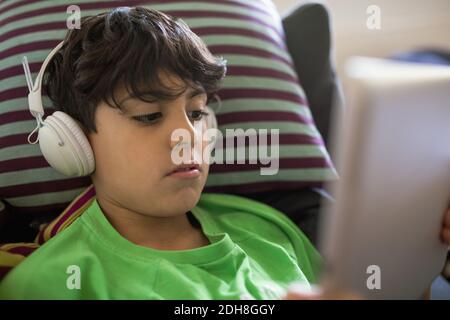 Boy listening music through digital tablet at home Stock Photo