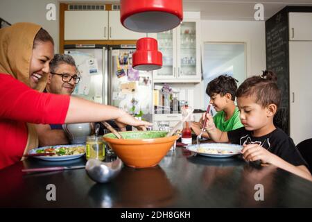 Happy family having meal at dining table Stock Photo
