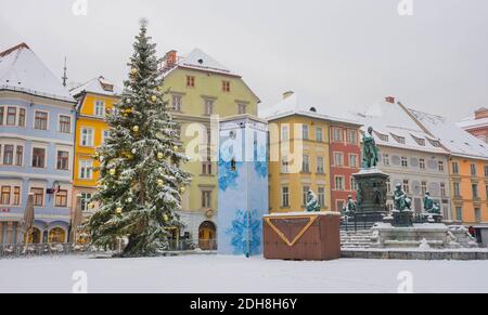 Graz, Austria - December 03, 2020: Beautiful Christmas tree at main square Hauptplatz with Erzherzog Johann fountain and historical buildings in winte Stock Photo