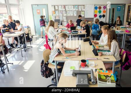 High school students sitting with teacher in classroom Stock Photo