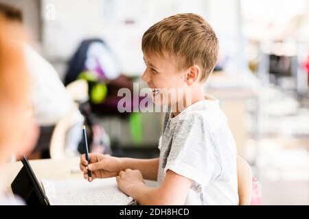 Cheerful boy in classroom at school Stock Photo