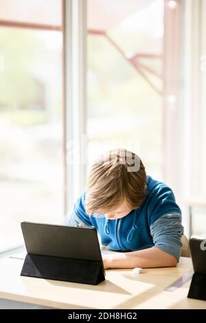 Boy using digital tablet for learning in classroom Stock Photo