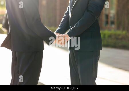 Midsection of newlywed gay couple holding hands Stock Photo