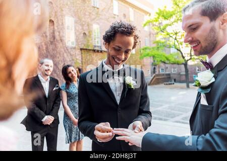 Gay couple exchanging rings during wedding ceremony Stock Photo