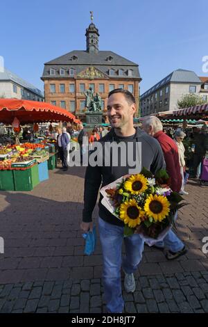 Young man with a bunch sunflowers at Hanauer Wochenmarkt Hessen, Germany Stock Photo