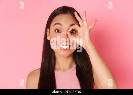 Beauty, fashion and lifestyle concept. Close-up of dreamy and cute asian young girl looking through okay gesture or showing zero Stock Photo