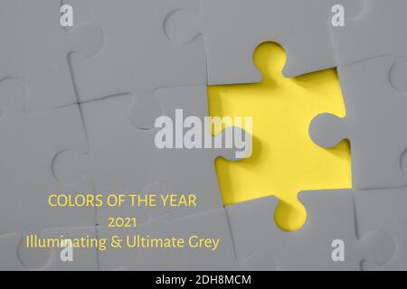 Multiple grey puzzle pieces put together without one piece on yellow background. Colors of year 2021. Place for text. Stock Photo