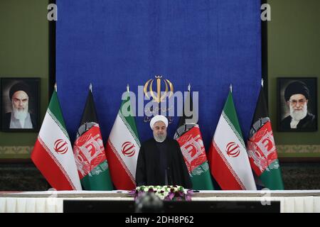 Tehran, Iran. 10th Dec, 2020. In this photo released by the official website of the office of the Iranian Presidency, President Hassan Rouhani stands at the start of a video conference with his Afghan counterpart to inaugurate the first railway link between the two countries, at the presidency palace in Tehran, Iran, Thursday, Dec. 10, 2020. The 140-kilometer (90-mile) line running from eastern Iran into western Afghanistan will eventually be expanded to reach the Afghan city of Herat, providing a crucial transport link for the landlocked country. (Credit Image: © Iranian Presidency via ZUM Stock Photo