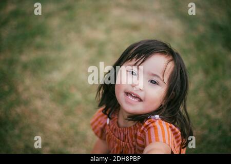 Portrait of smiling down syndrome girl playing in yard Stock Photo