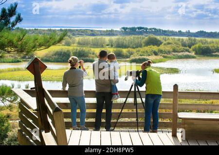 Somme Bay (northern France): bird watching outing in the bird sanctuary “Parc du Marquenterre”, in Saint-Quentin-en-Tourmont. Family and guide on an o Stock Photo