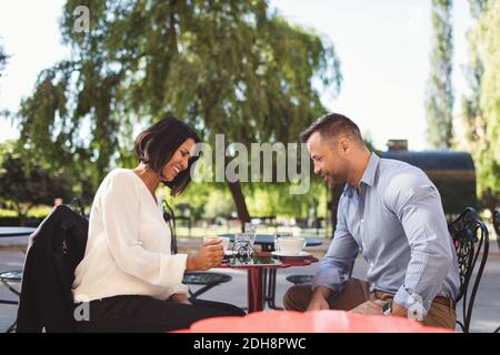 Business colleagues using digital tablet at sidewalk cafe Stock Photo