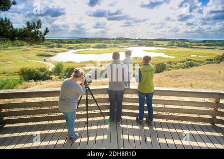 Somme Bay (northern France): bird watching outing in the bird sanctuary “Parc du Marquenterre”, in Saint-Quentin-en-Tourmont. Family and guide on an o Stock Photo