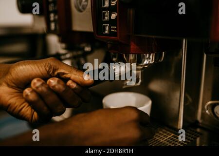 Cropped hand of male owner making coffee in cafe Stock Photo