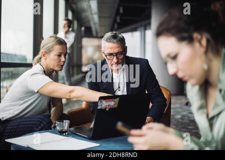 IT professional assisting contemplating businessman in office corridor Stock Photo