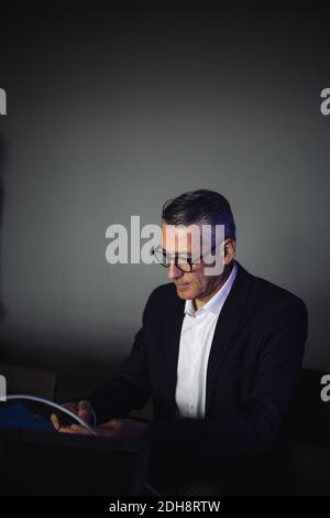 Confident mature engineer working against wall in office Stock Photo