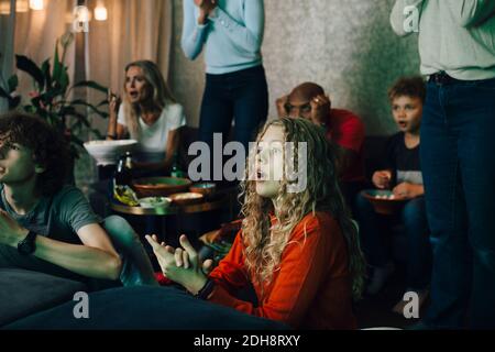 Disappointed family watching sports on TV at night Stock Photo