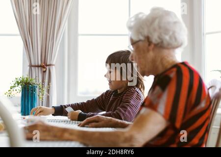Boy playing cards with great grandmother at home Stock Photo