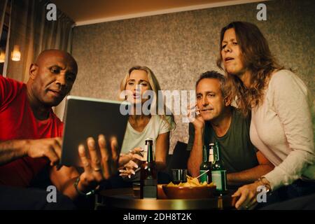 Man showing digital tablet to friends during sporting event Stock Photo