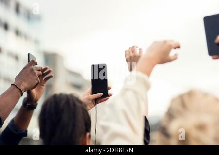 Low angle view of friends holding smart phones Stock Photo