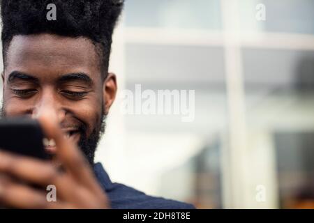 Low angle view of happy man using phone Stock Photo