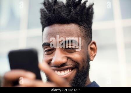 Low angle view of happy man using smart phone Stock Photo