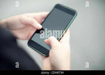 Cropped image of woman using smart phone Stock Photo