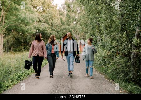 Smiling daughters with father and mother walking on footpath during vacations Stock Photo