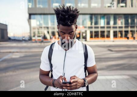 Young man using phone while in city Stock Photo