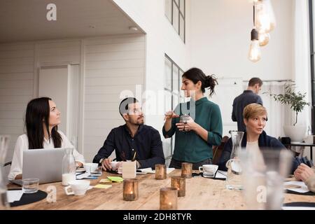 Businesswoman talking with colleagues at meeting in office Stock Photo