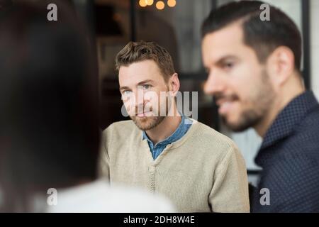 Businessmen looking at woman during meeting in office Stock Photo