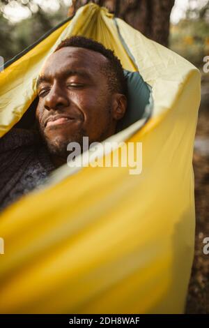 Man sleeping in hammock at forest Stock Photo
